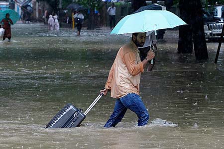 مسافری در خیابان های آب گرفته بمبئی، هند