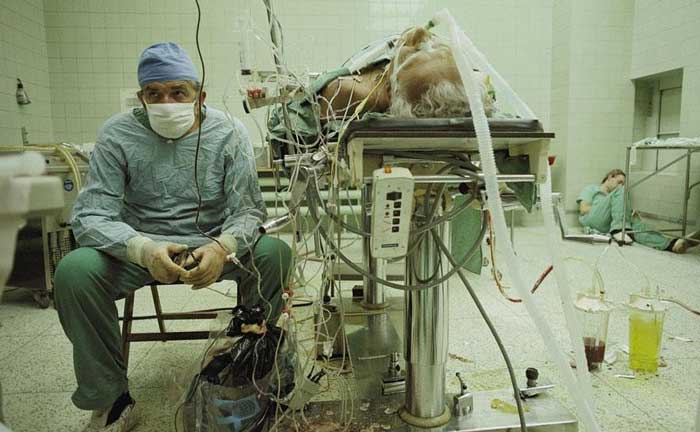 28. Heart surgeon after 23-hour-long (successful) heart transplant. His assistant is sleeping in the corner.
